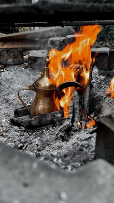 a kettle sitting on top of a fire pit