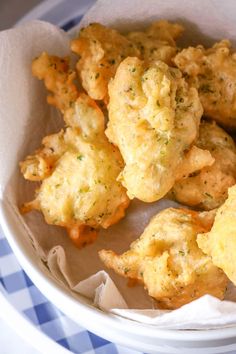 a bowl filled with fried food on top of a blue and white checkered table cloth