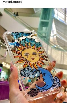 someone holding up their phone case with the sun and moon on it