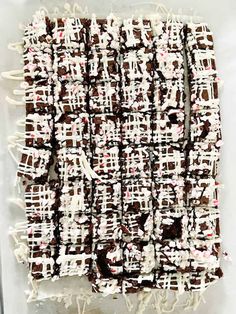 chocolate squares with white icing and sprinkles on a sheet of paper