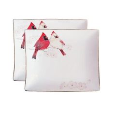 two white plates with red birds painted on them