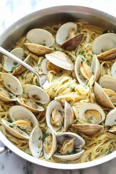 pasta with clams and parmesan cheese in a pan