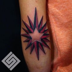 a red and black star tattoo on the left arm, with an arrow in the center