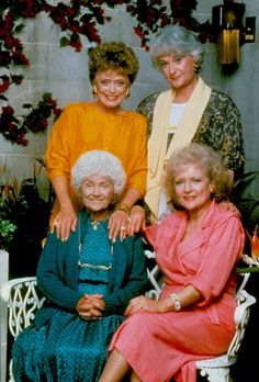 an old photo of three women sitting next to each other on a chair in front of a wall with flowers