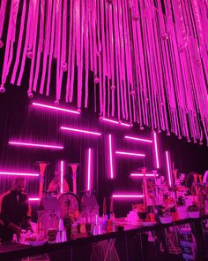 neon lights hang from the ceiling above a bar