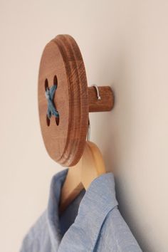 a wooden coat rack with a blue shirt on it