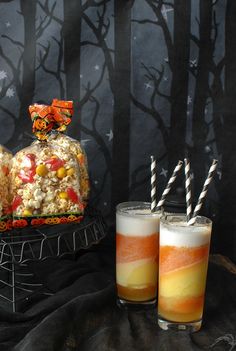 two glasses filled with drinks next to halloween treats