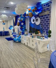 a blue and white baby shower party with balloons, decorations and desserts on the table