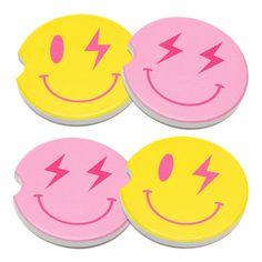 three smiley face coasters with pink and yellow faces, one has a lightning bolt on it