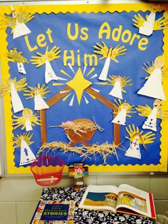 a bulletin board decorated with paper cutouts and nativitys on it's side