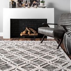 a living room with a fireplace, chair and rug