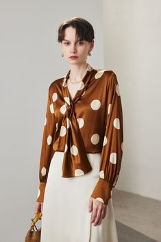 Polka Dot Charm in Luxurious Mulberry Silk Capture the essence of timeless sophistication with this vintage-inspired silk blouse. The delicate brown and white polka dot pattern exudes a classic charm, while the elegant tie at the neckline adds a touch of refined grace. This blouse's sleek tailoring ensures a smooth silhouette, making it perfect for pairing with solid pants or skirts for a poised office or casual look. Style #: WWAJ164 Patterned Blouse, Silk Knit, Vintage Tie, Shearling Coat, Fur Fashion, Tie Neck, Mulberry Silk, Spring Collection, Silk Top