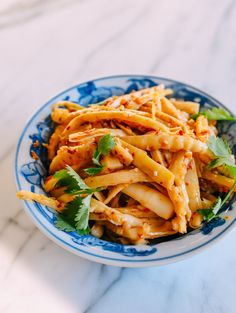 a blue and white bowl filled with pasta