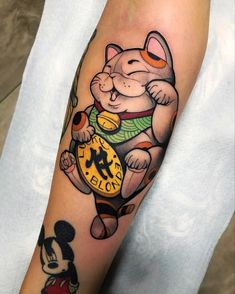 a person with a mickey mouse tattoo on their arm, holding a clock in his hand