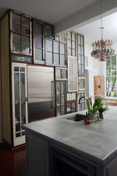 a kitchen with an island and stainless steel appliances in the center, surrounded by windows