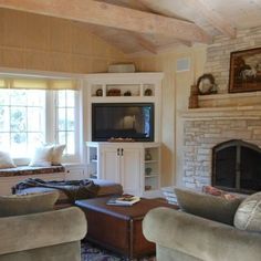 a living room filled with furniture and a flat screen tv on top of a fireplace