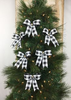 a christmas tree decorated with black and white bows