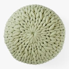 a round cushion made out of knitted yarn on a white background, top view