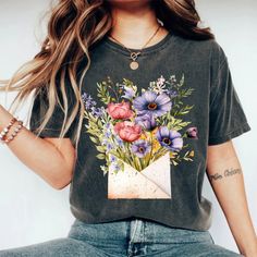 Introducing the Boho Wildflowers Shirt - a delightful and thoughtful gift for her that beautifully captures the essence of nature and free-spirited style. Crafted from the finest, softest cotton, this floral tee is a wearable celebration of the blooming wildflowers that inspire joy and tranquility. Its charming design, featuring an array of intricately illustrated wildflowers, makes it a perfect shirt for flower lovers and a trendy addition to any wardrobe. PRODUCT DESCRIPTION: Made with 100% Ai Boho Wildflower, Wildflower Shirt, Thoughtful Gifts For Her, Free Spirit Style, Floral Tee, Prism Color, Free Spirited, Flower Lover, Floral Shirt