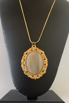 This beautiful brown stone cabochon brooch pendant is 2 inches wide and 2 1/2 inch tall.  The stone is set in a bright gold plated  setting.  It hangs on a snake chain that is 24 inches long and also gold plated.   I specialize in finding fun wearable jewelry.  Please browse my shop for more options.  I box all jewelry sales ready to be given as gifts. I can often combine multiple item purchases to save on shipping. Please contact me if you wish to do this. Oval Stone Pendant Designs, Gold Stone Pendant Designs, Oval Cabochon Pendant, Stone Lockets Pendants, Stone Pendants Gold, Stone Pendent Designs Gold, Stone Pendent Designs, Wearable Jewelry, Jewel Wedding