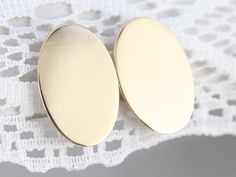 Beautifully polished and simple-as-can-be in design. These gleaming yellow gold oval studs were adapted from a pair of antique cufflinks and given a bright polish. Wear these minimalist studs everyday with a suit-dress or jeans! Market Square Jewelers works with one of the finest hand engravers in the northeast. With over 30 years of experience, our engraver hand carves lettering, monograms, crests, or patterns in period-specific styles. Choose from our many monogram options shown in the listing Plain Gold Earrings, Antique Cufflinks, Monogram Earrings, Oval Stud Earrings, Market Square, Minimalist Studs, Suit Dress, Cameo Ring, July Birthstone