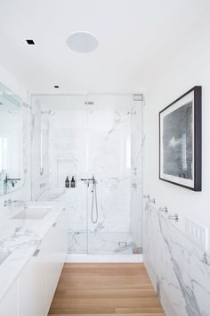 a white bathroom with marble walls and floors