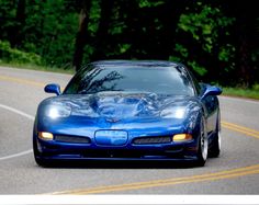 a blue sports car driving down the road