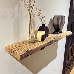 a wooden shelf with candles and vases on it