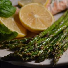 asparagus and lemon slices on a white plate