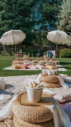 an outdoor picnic setting with food and umbrellas in the background at a wedding reception