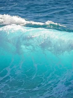 a man riding a wave on top of a surfboard in the middle of the ocean