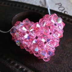 a pink heart shaped beaded necklace sitting on top of a table