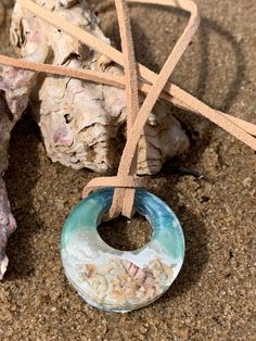 Beautiful sea inspired resin pendant on a leather necklace. Hand poured resin capturing the feel of waves on the beach. Embedded with a selection of tiny collected dried shells and sand representing the life, energy and essence of the ocean. A perfect summer beach accessory. Hand made in Sydney, Australia by Renae Joy. Adjustable Round Pendant Necklace For Beach, Ocean-inspired Round Necklace For Beach, Resin Round Pendant Jewelry For Beach, Bohemian Resin Jewelry For Beach, Bohemian Resin Jewelry For The Beach, Bohemian Beach Resin Jewelry, Ocean-inspired Round Beach Necklace, Adjustable Round Shell Necklace For Beach, Adjustable Round Shell Necklace For The Beach