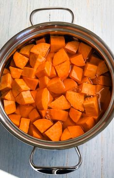 a large pot filled with lots of cut up carrots on top of a table