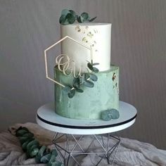 a green and white cake sitting on top of a table next to some plants in front of a wall