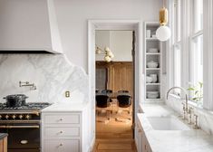 a kitchen with marble counter tops and white cabinets