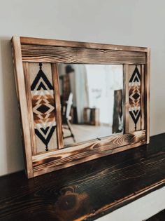 a mirror sitting on top of a wooden shelf