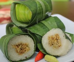 some food is on a white plate with green leafy leaves and carrots next to it