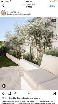 an outdoor seating area with white furniture and trees in the back yard is featured on instagram