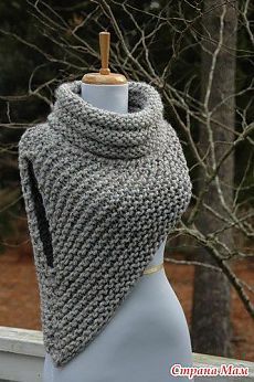 a gray knitted shawl on a mannequin with trees in the background