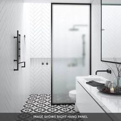 a white bathroom with black and white floor tiles on the walls, an open glass shower door