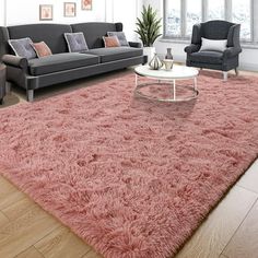 a living room filled with furniture and a pink rug