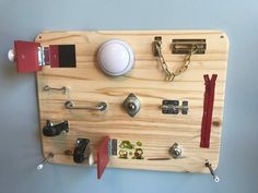 a wooden board with various items attached to it and hanging on the wall next to each other