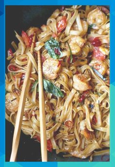 stir fry noodles with shrimp and vegetables in a wok, ready to be eaten