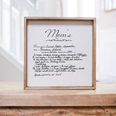 a framed menu is sitting on top of a wooden table in front of the stairs