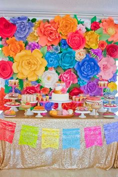 a table topped with lots of colorful paper flowers