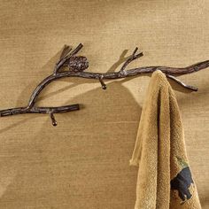 a towel hanging on a wall next to a tree branch with two birds perched on it