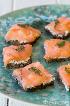 small pieces of food on a plate with some dill sprinkled on top