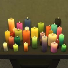 many different colored candles sitting on a table