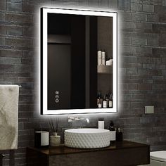 a bathroom with a sink, mirror and towel rack in front of a brick wall